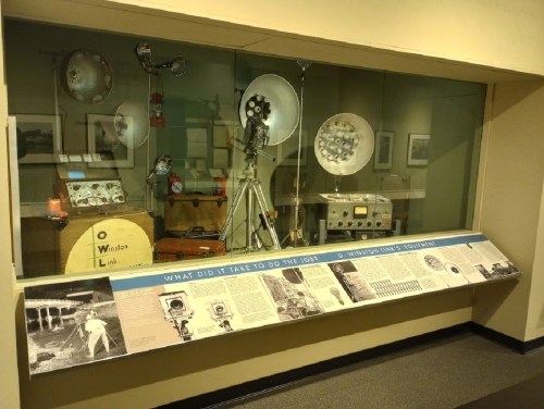 Display case featuring vintage photography equipment and informational panels about Winston Link's work.