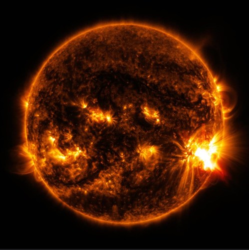 A vibrant image of the sun, showcasing solar flares and dynamic surface activity against a dark background.