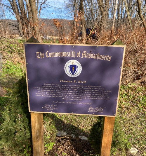 A plaque from the Commonwealth of Massachusetts honoring Thomas E. Reed, set in a wooded area.