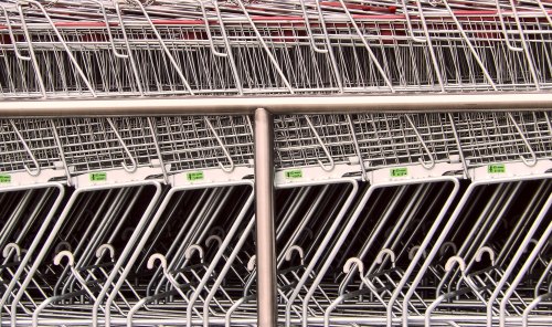 A close-up of neatly arranged shopping carts stacked in a row, showcasing their metallic structure and handles.