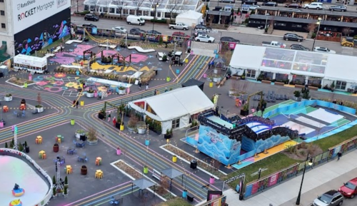 Aerial view of a vibrant outdoor event space with colorful pathways, seating areas, and entertainment stages.
