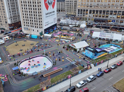 Aerial view of a vibrant outdoor event space with colorful attractions, rides, and a skating rink.