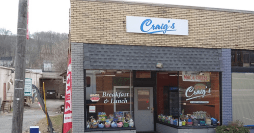 A storefront with a sign reading "Craig's" offering breakfast and lunch, featuring colorful displays in the window.