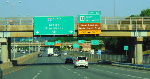 Highway scene with signs for Groton, Providence, and Norwich; vehicles traveling on a multi-lane road.