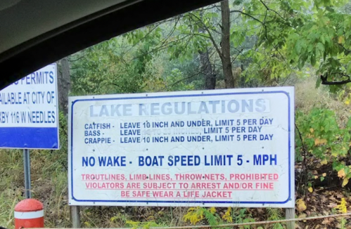 Sign displaying lake regulations: limits on fish sizes and quantities, no wake zone, and boat speed limit of 5 mph.