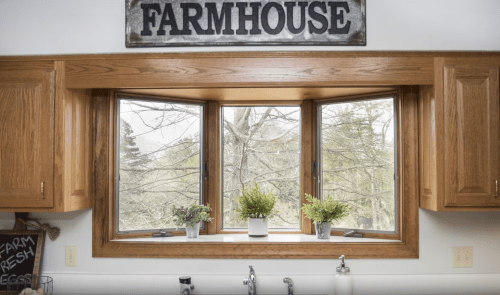 A cozy kitchen window with wooden frames, potted plants, and a "FARMHOUSE" sign above, overlooking a green landscape.