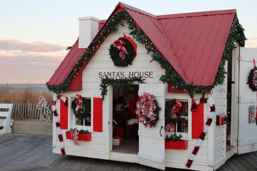 A festive small house decorated for Christmas, labeled "Santa's House," with wreaths and candy canes.