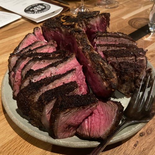 A plate of perfectly cooked, sliced steak with a crispy crust, showcasing a juicy pink interior.
