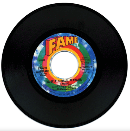 A vintage vinyl record labeled "Muscle Shoals, Alabama" by Travis Wammack, featuring colorful artwork.
