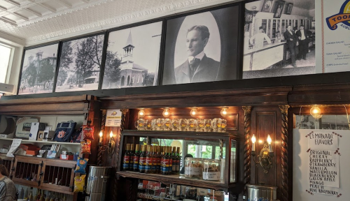 Historic photos and a vintage bar display with various drinks and a menu of lemonade flavors.