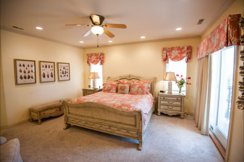 Cozy bedroom with a floral-patterned bedspread, elegant furniture, and soft lighting.