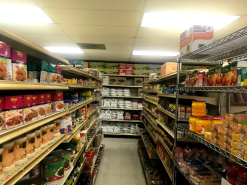 A grocery store aisle filled with shelves of various packaged food items and canned goods.