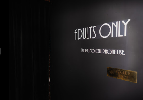 A dark wall with a sign reading "ADULTS ONLY" and "PLEASE, NO CELL PHONE USE" next to a plaque labeled "BOGLE'S PLACE."