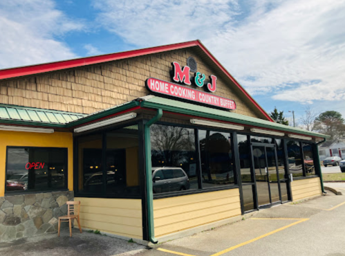 Exterior of M&J Home Cooking Country Buffet, featuring a colorful sign and large windows, with an "Open" sign visible.