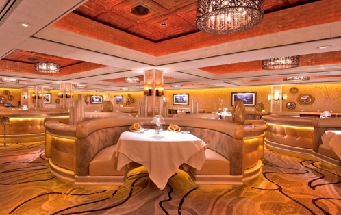 Elegant restaurant interior with plush seating, warm lighting, and decorative chandeliers. Cozy dining atmosphere.