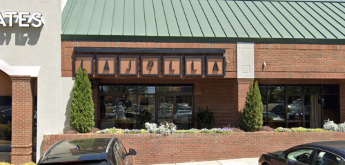 Exterior view of a brick building with a green roof, featuring the sign "LA JOLLA" above the entrance.