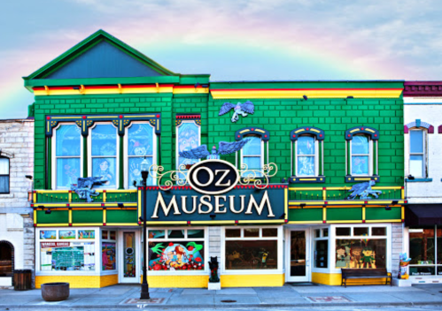 Colorful exterior of the Oz Museum, featuring green walls, decorative elements, and a rainbow in the background.