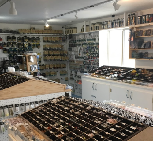 A well-organized store interior with shelves of fishing supplies and a display of various fishing lures and accessories.