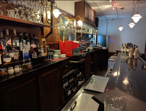 A well-stocked bar with various bottles, glassware, and a polished countertop in a cozy setting.