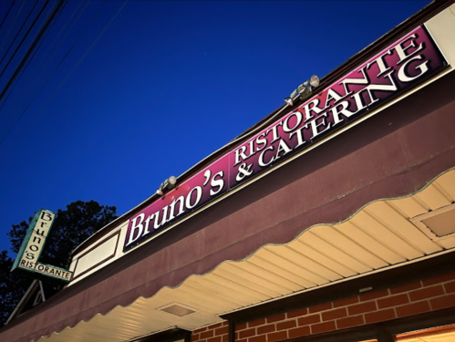 Signage for Bruno's Ristorante & Catering illuminated at dusk, featuring a classic restaurant facade.