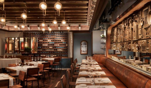 Elegant restaurant interior with wooden beams, warm lighting, and stylish seating arrangements.
