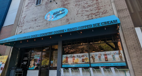 Exterior of a restaurant featuring a blue awning with text about menu items, including ice cream and country goods.