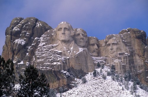 Mount Rushmore featuring the carved faces of four U.S. presidents against a snowy mountain backdrop.