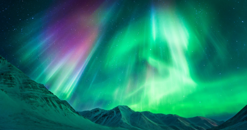 Vibrant auroras dance over snow-capped mountains under a starry night sky, showcasing shades of green and purple.