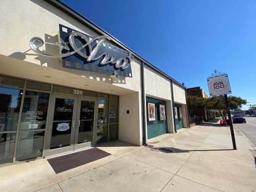 Exterior of a building with a sign reading "Ava" and a storefront entrance, on a sunny day.
