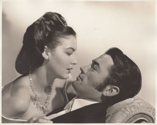 A romantic black-and-white portrait of a couple gazing into each other's eyes, exuding intimacy and elegance.