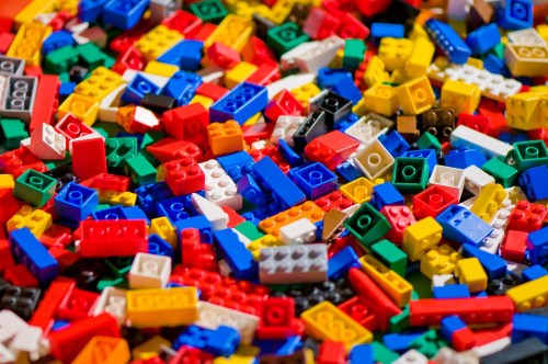 A colorful assortment of LEGO bricks in various shapes and sizes scattered on a surface.