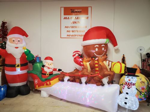 Inflatable Christmas decorations: Santa, gingerbread man, and snowman with a sign stating no exchanges or refunds.