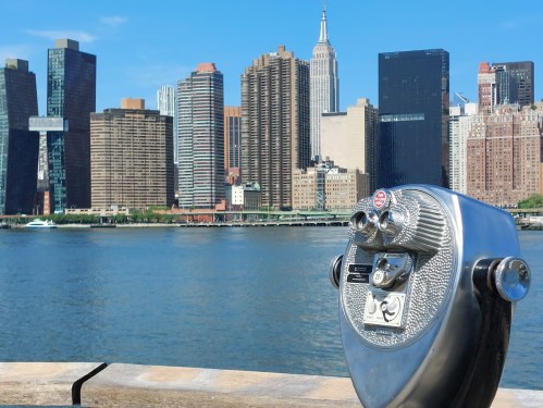 A coin-operated binocular viewer with a city skyline and the Empire State Building in the background.