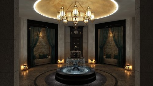 A luxurious indoor space featuring a central fountain, elegant lighting, and cozy seating areas with soft drapes.