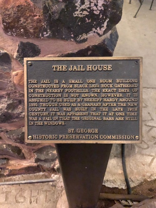 Plaque describing the Jail House, a small one-room building made of black lava rock, with historical context.