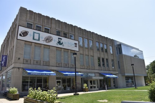 Exterior of the Massillon Museum featuring a large banner and blue awnings on a sunny day.