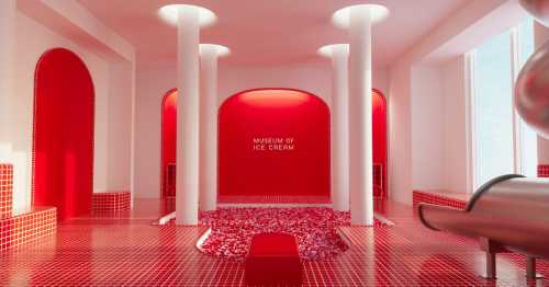 Bright red interior of the Museum of Ice Cream, featuring white columns and a playful, modern design.