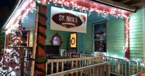 A festive storefront decorated with holiday lights and a sign reading "St. Nick's" in a colorful setting.