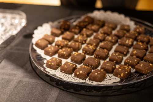 A platter of chocolate-covered treats arranged neatly on a lace doily.