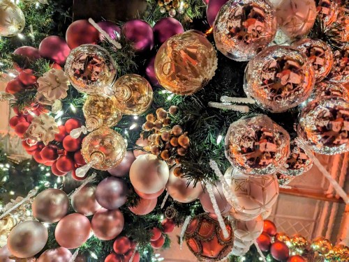 A close-up of a festive Christmas tree adorned with colorful ornaments and twinkling lights.