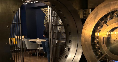 A vault door in the basement of a former bank opens onto a modern speakeasy.