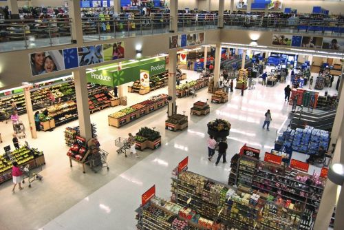 Aerial view of a grocery store with produce section, aisles of products, and shoppers with carts.