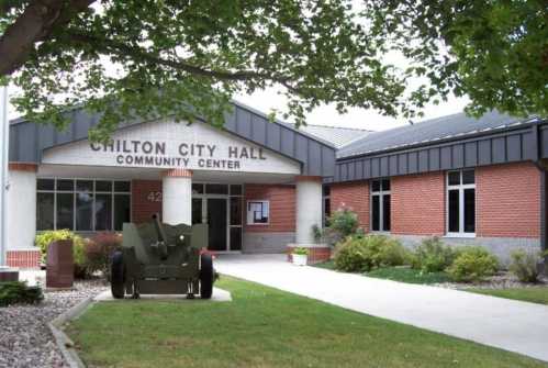 Chilton City Hall Community Center with a green cannon in front and landscaped grounds.