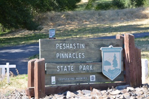 Sign for Peshastin Pinnacles State Park, featuring the park's name and a Washington state emblem.