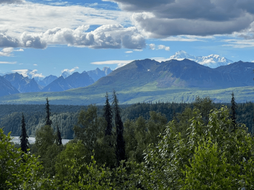 A scenic view of mountains and lush greenery under a partly cloudy sky.