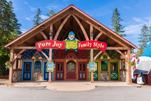 A colorful, whimsical building with a sign reading "Pure Joy Family Style" surrounded by trees and a clear blue sky.