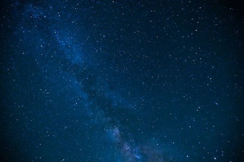 A starry night sky filled with countless stars and a visible Milky Way galaxy.