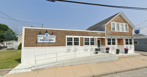 Exterior view of the Blue Anchor Grill, a two-story building with a shingled facade and accessible ramp.