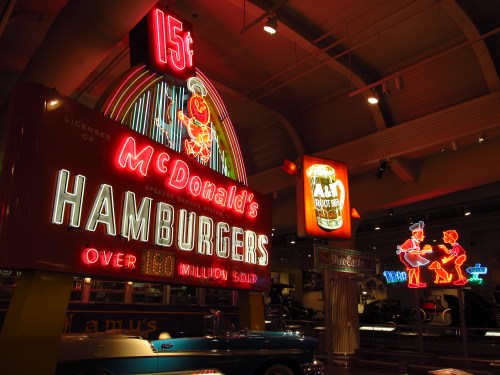 Vintage McDonald's neon sign advertising hamburgers for 15 cents, with colorful lights and retro design elements.
