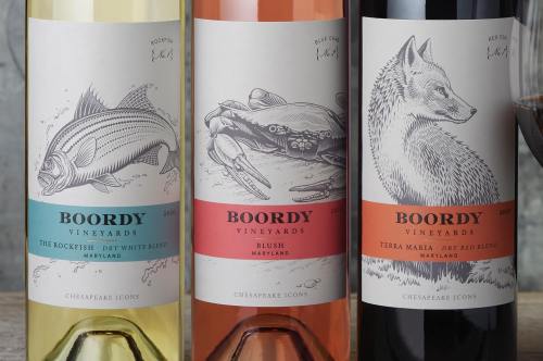 Three wine bottles from Boordy Vineyards featuring illustrated labels: a fish, a crab, and a fox, with color-coded designs.